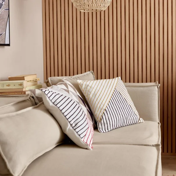 Beżowa sofa z poduszkami w geometryczne wzory